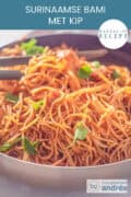 Een deel van een wok gevuld met Surinaamse bami met kip en selderij. Een tekst: makkelijk recept, Surinaamse bami met kip