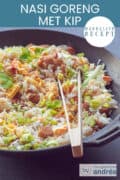 Een deel van een wok op een donkere achtergrond met nasi goreng, kip, spekjes, ham en groenten. Een tekst bovenin: makkelijk recept, nasi goreng met kip