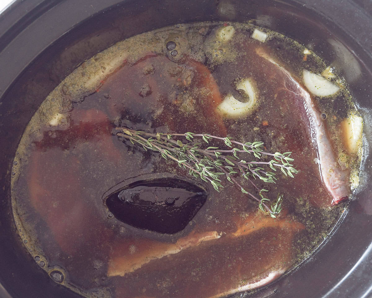 Sukadelapjes met appelstroop, bier en bouillon en tijm in een slowcooker