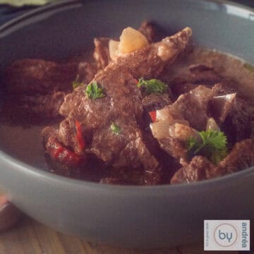 Een vierkante foto met een grijze schaal met beef trinchado uit de slowcooker.