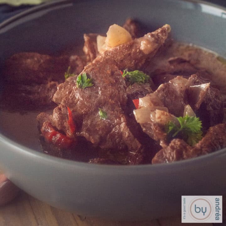 Een vierkante foto met een grijze schaal met beef trinchado uit de slowcooker.