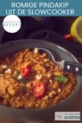 Een deel van een grijze kom met malse kip en satésaus. Een tekst bovenin: makkelijk recept, romige pindakip uit de slowcooker