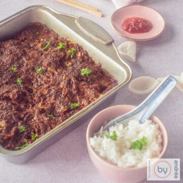 Een vierkante foto met een bakblik gevuld met frikadel pan, een roze kom met witte rijst en een schaaltje met sambal.