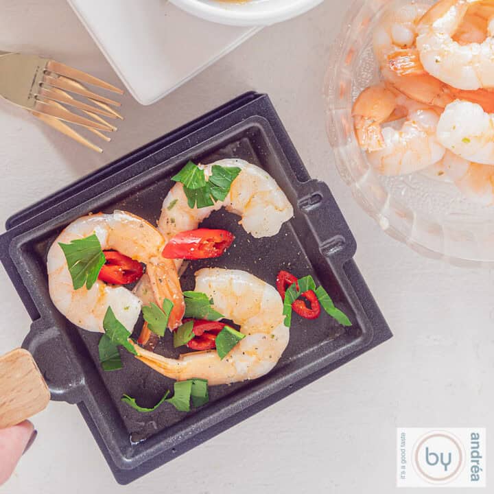 Een vierkante foto met een gourmet schaaltje met garnalen piri piri