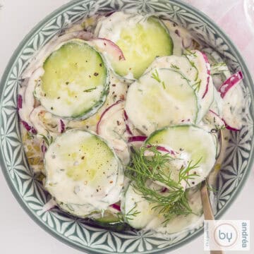 Een groene kom met Griekse komkommersalade met ui en dille