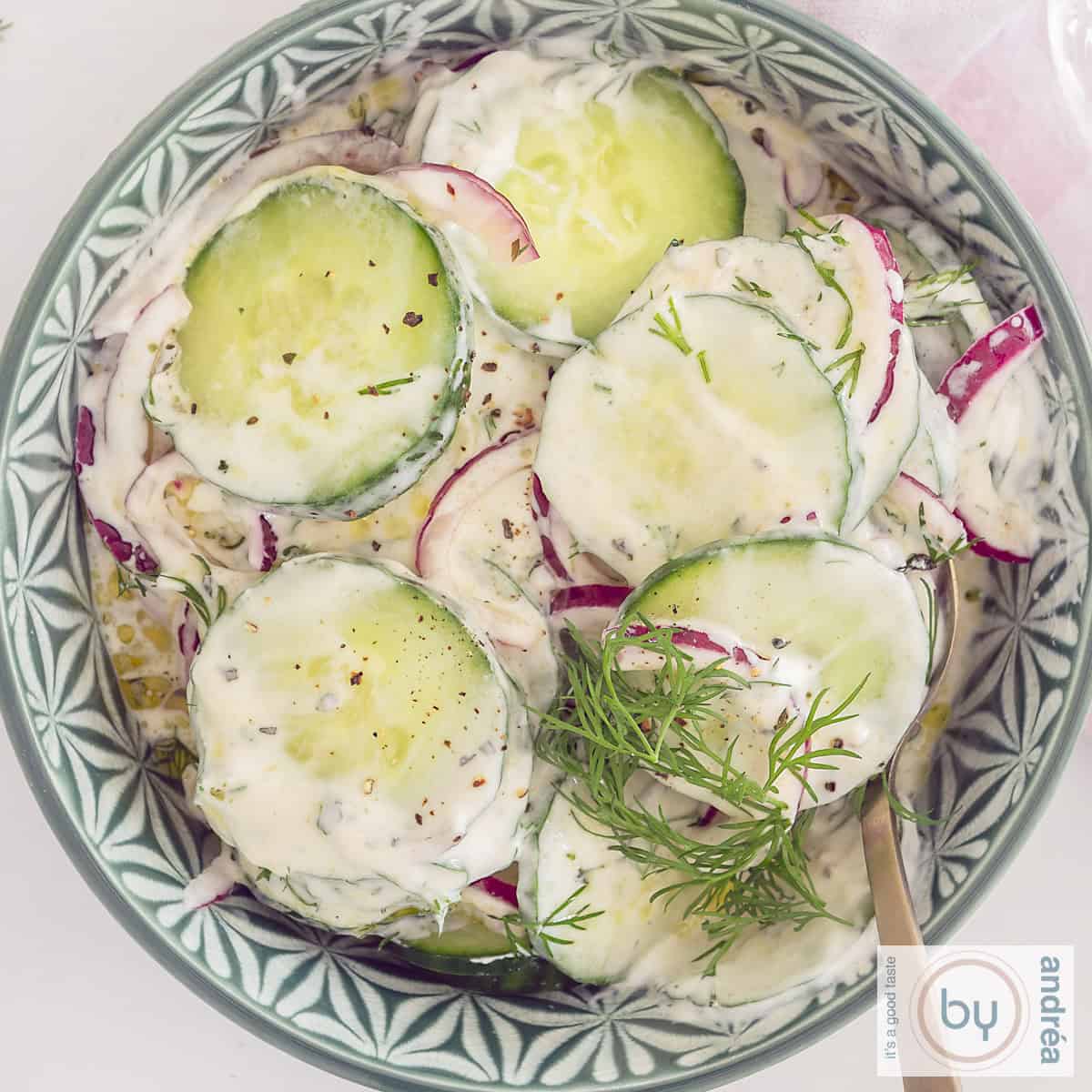 Een groene kom met Griekse komkommersalade met ui en dille