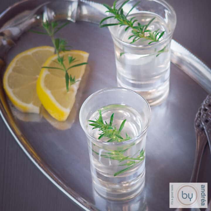 Een vierkante foto met een ouzo cocktail op een zilveren schaal