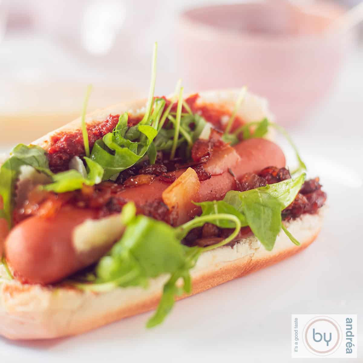 Een broodje met een hotdog en topping