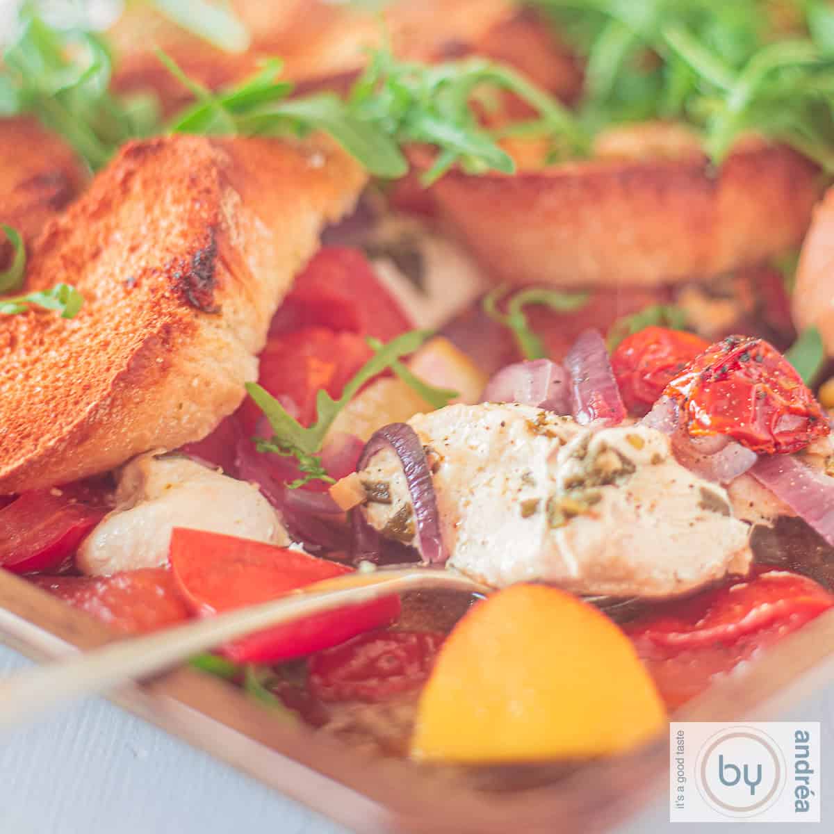 Een vierkante foto met een Italiaanse ovenschotel met citroen tomaat en rucola