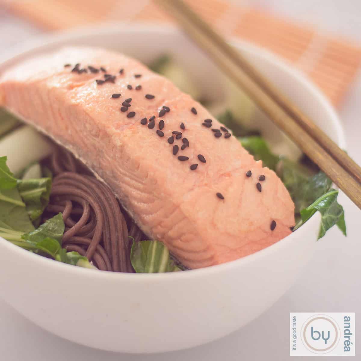 Een witte schaal met Japans gepocheerde zalm, noedels en groenten