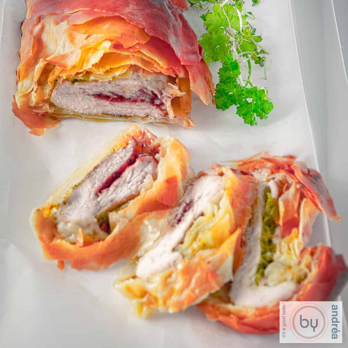 Een vierkante foto met kalkoenfilet gevuld met cranberries in filodeeg gebakken