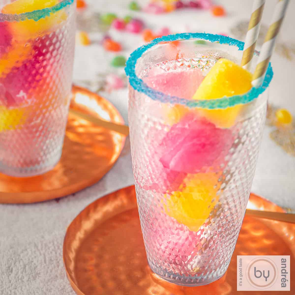 Een vierkante foto met een versierd glas met limonadesiroop ijsklontjes