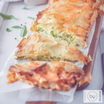 Een vierkante foto met een kolokithopita quiche met courgette.