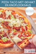 Een deel van een pizza met een punt eruit. Belegt met gehakt, tacokruiden, sla en knoflooksaus. Een tekst bovenin: makkelijk recept, pizza taco met gehakt en knoflooksaus