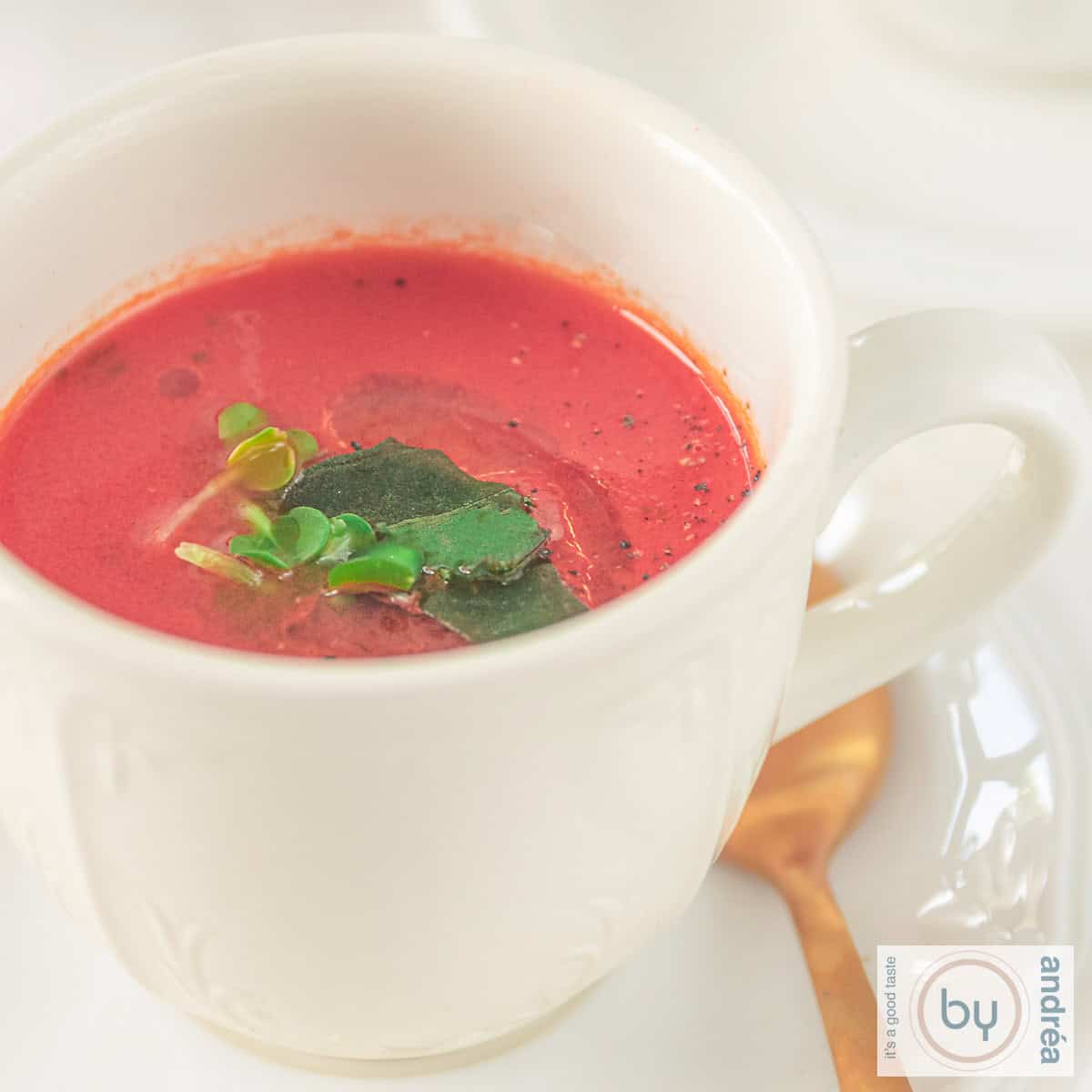 Een vierkante foto met een kopje met tomatensoep