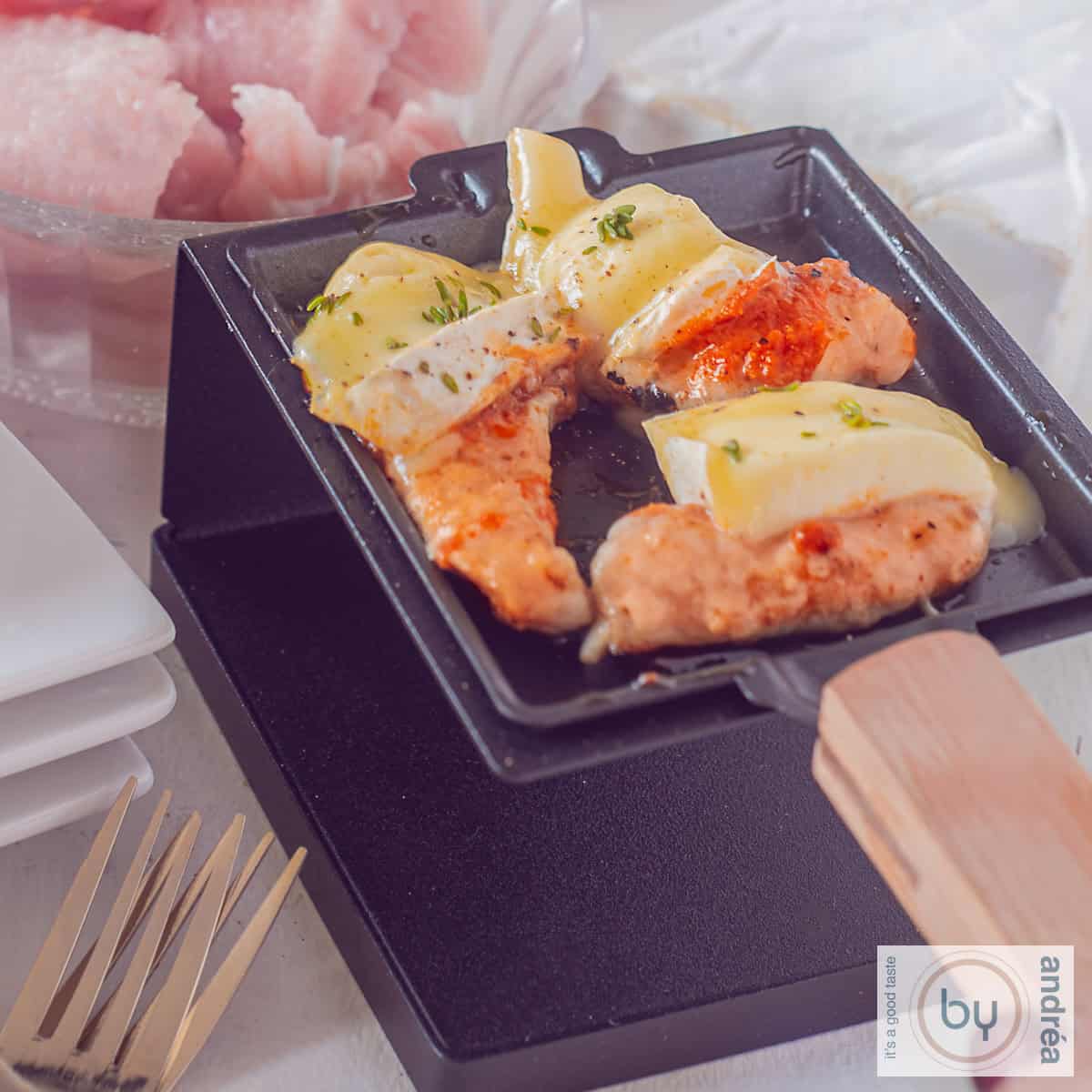 Een vierkante foto van een gourmetpannetje met schnitzel rode pesto en brie