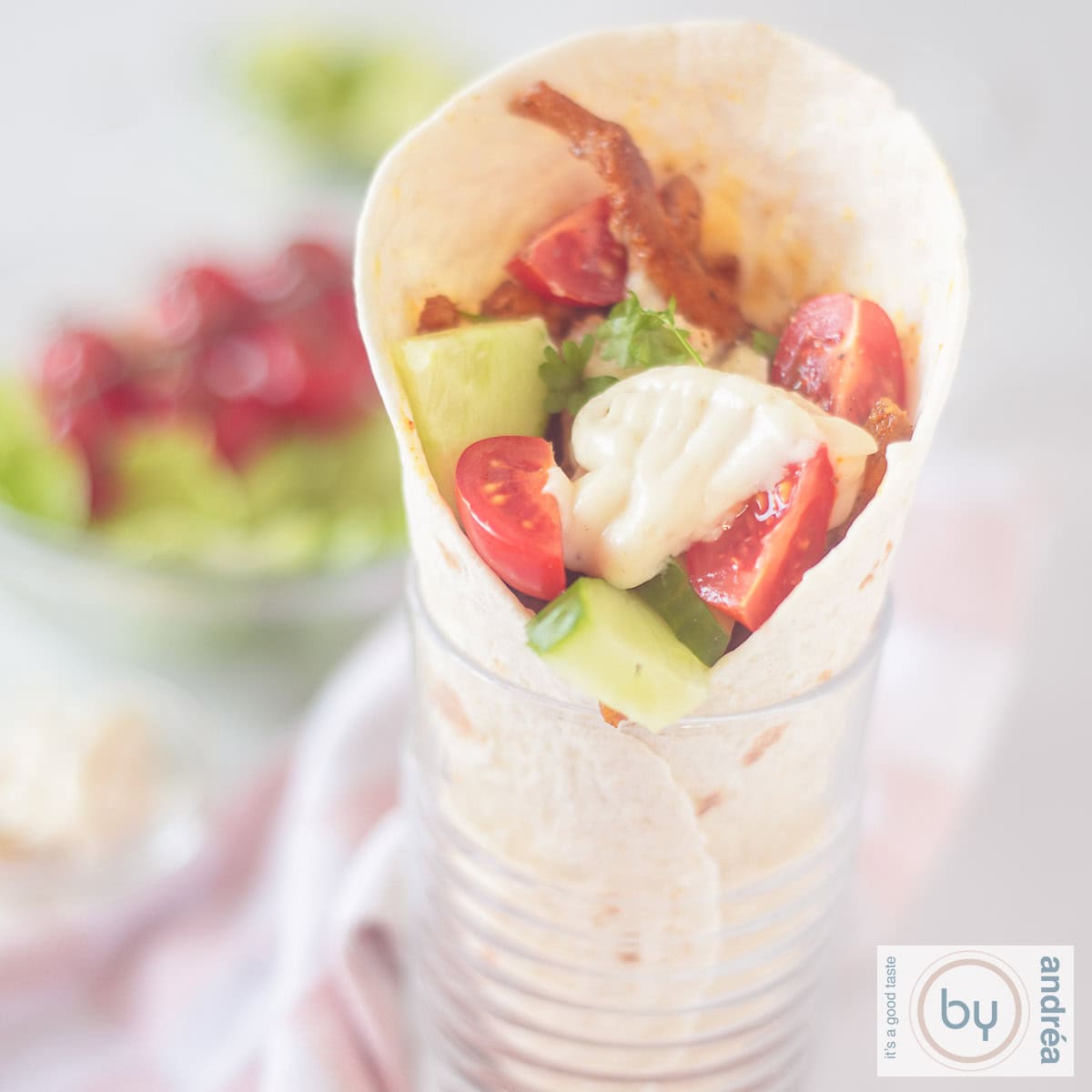 Een shoarma wrap met rauwkost en knoflooksaus in een glas.