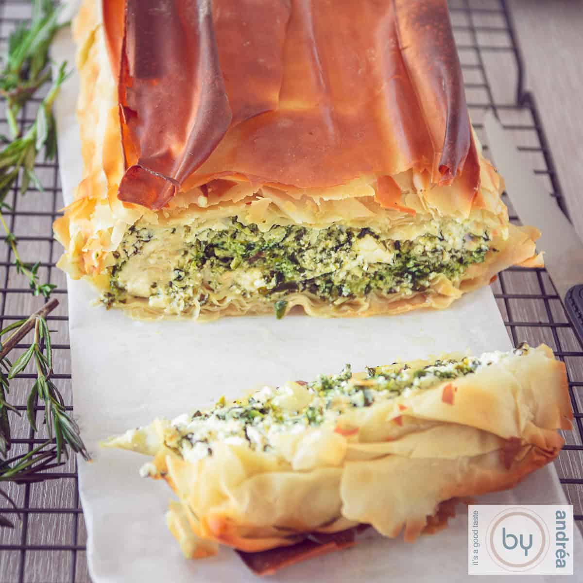 Een vierkante foto met een spinazie ricotta en feta cake ope en bakpapier