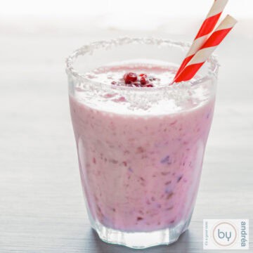 Granaatappel cranberry kokos smoothie op een grijze ondergrond