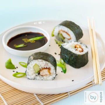 Een vierkante foto met een bord met drie rolletjes Kentucky sushi