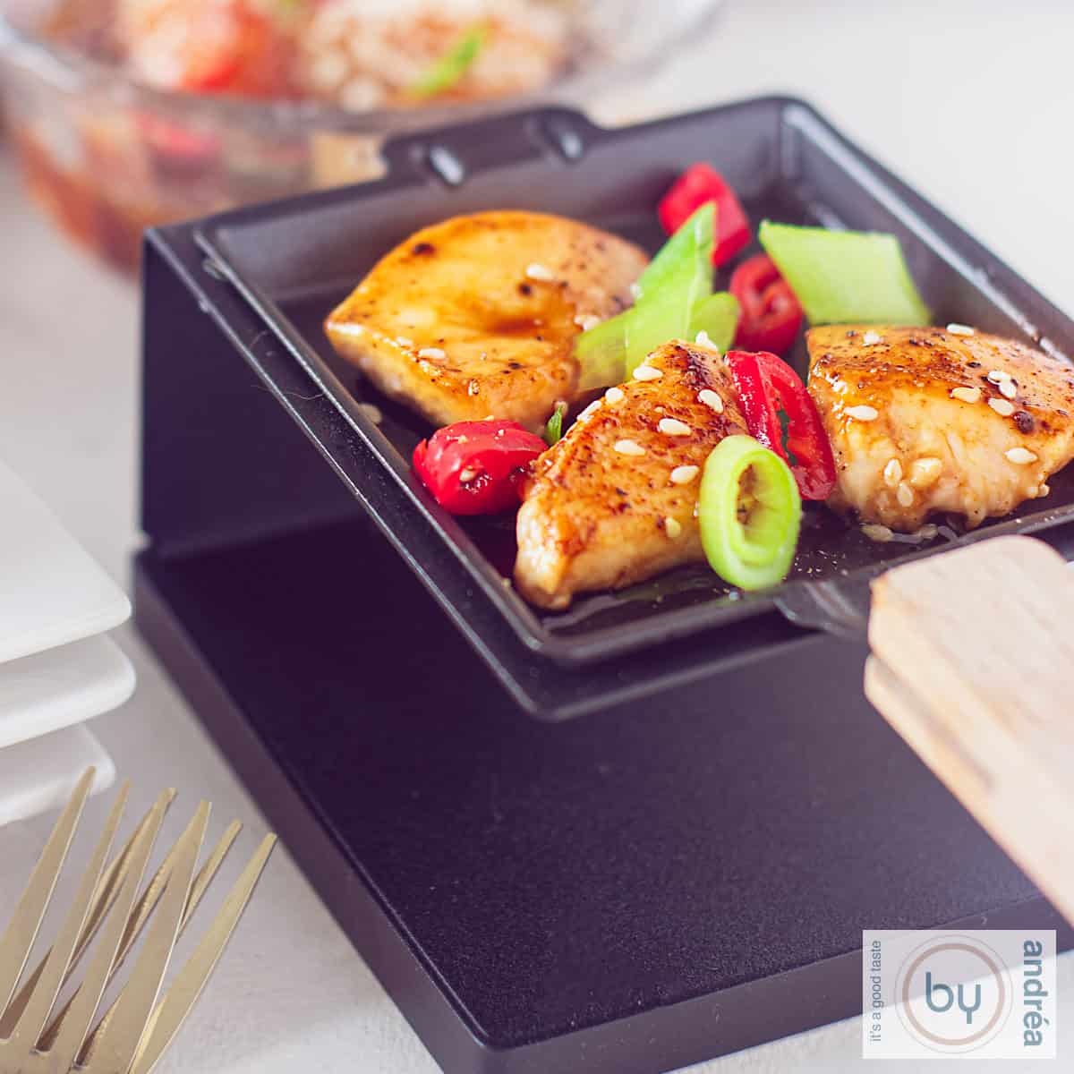 Een vierkante foto van kip in sojasaus in een gourmet pannetje