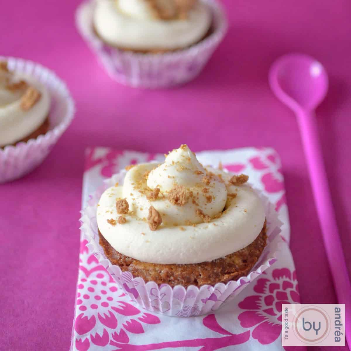 Een vierkante foto met pepernoten cupcakes op een roze achtergrond