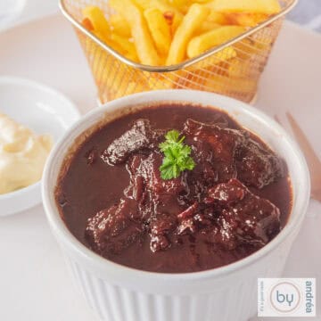 Een schaaltje met zuurvlees en frietjes en mayonaise