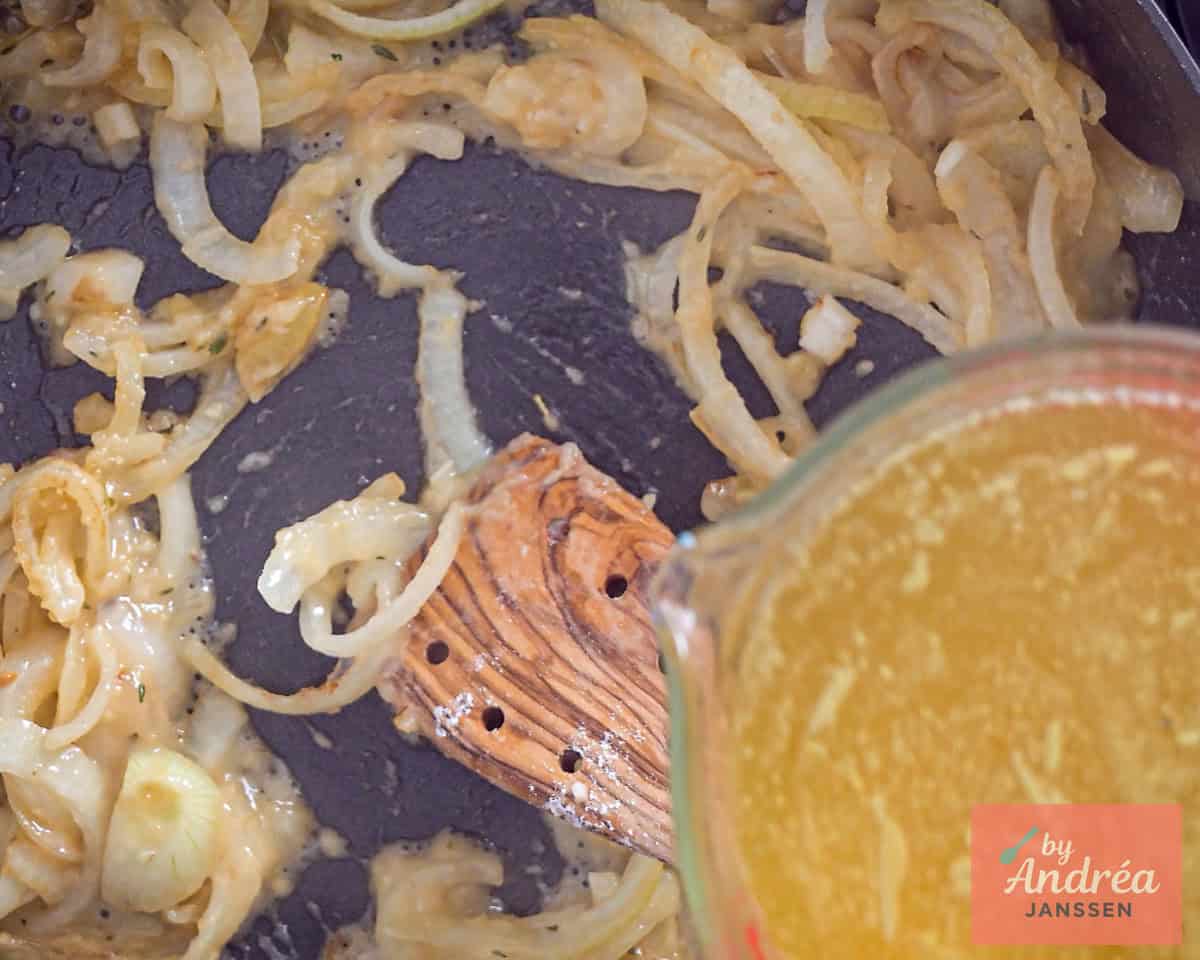 Bouillon wordt toegevoegd aan een pan met ui