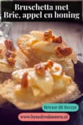 Een deel van een zwart schaaltje met stokbrood met brie, appel, walnoot en honing. Een tekst: bruschetta met brie, appel en honing.