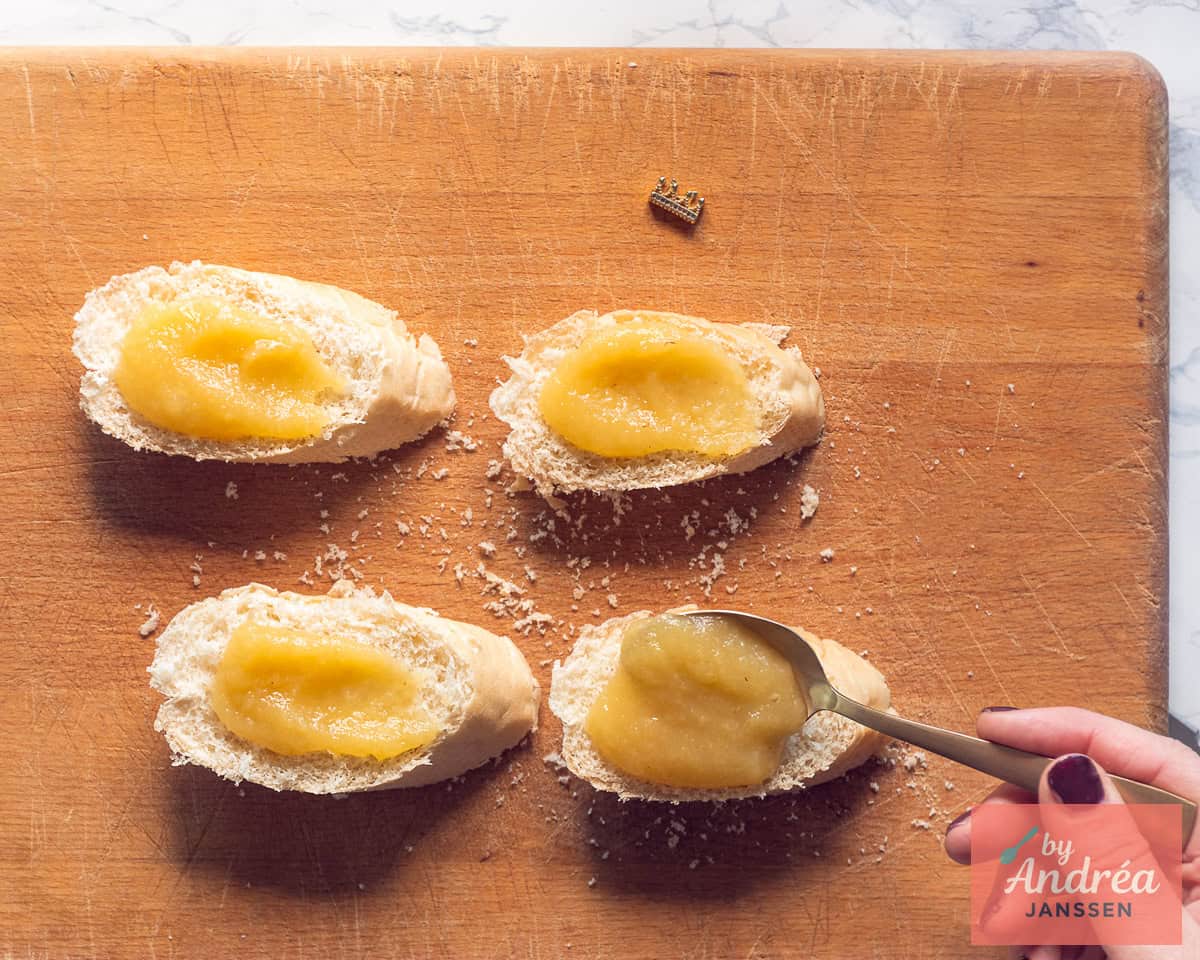 Op plakjes stokbrood wordt appelmoes gesmeerd