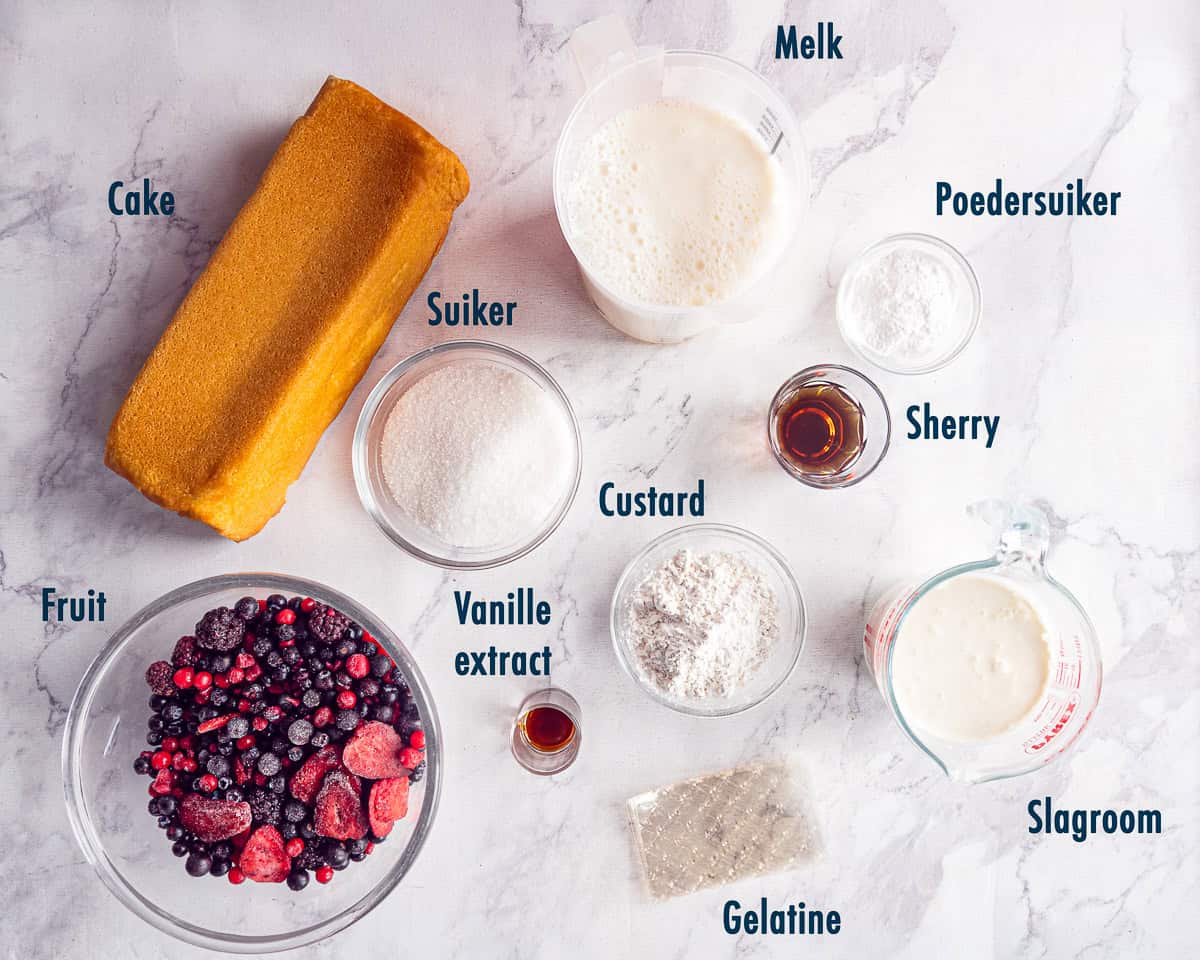 Ingredienten Rood Fruit Trifle Met Custard En Slagroom op een wit marmeren ondergrond met tekst beschrijving