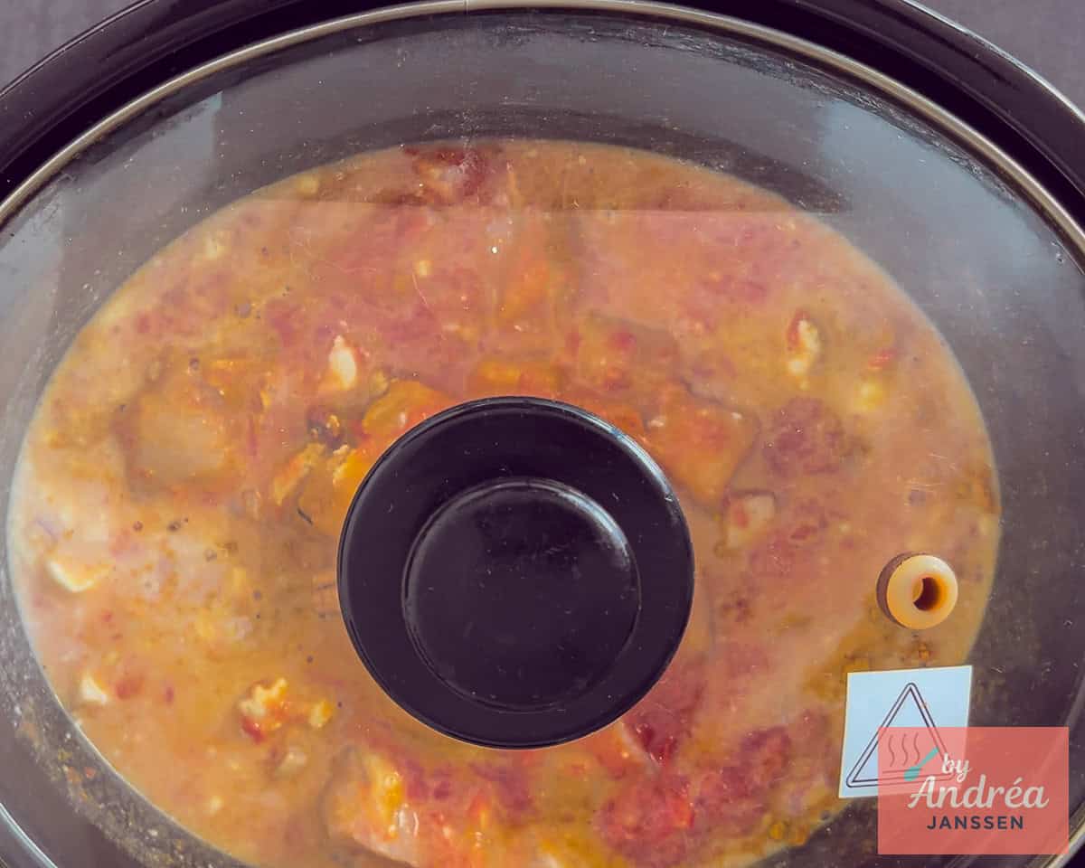 Een slowcooker gevuld met kip kerrie