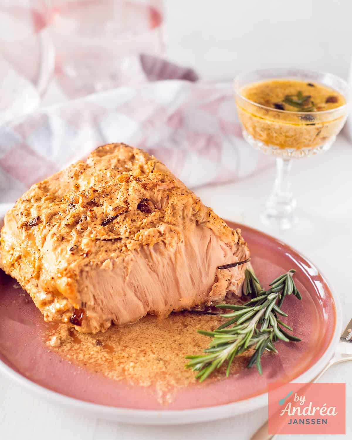 Slowcooker rollade van varkensfilet met romige uiensaus op een roze bord