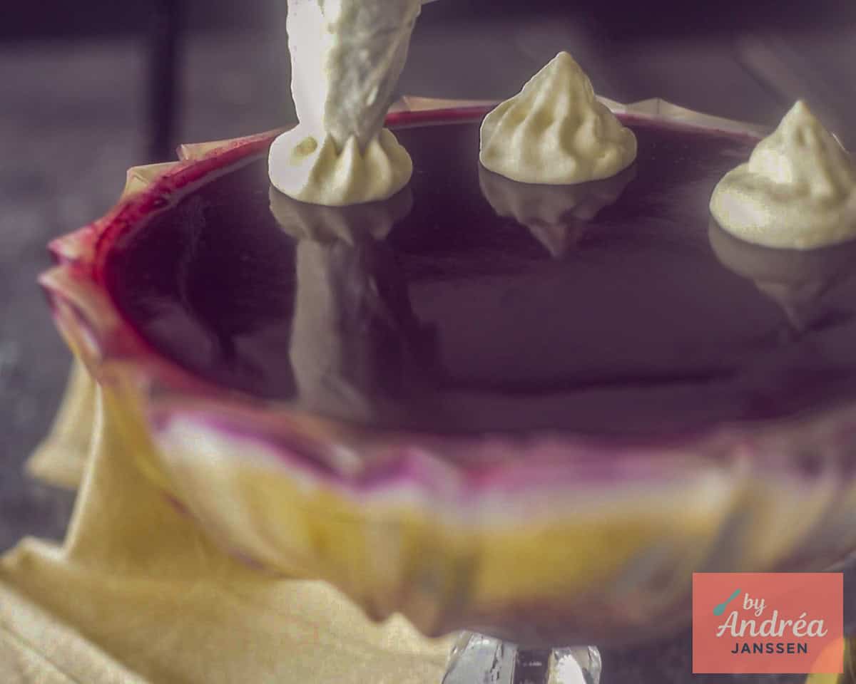 Een slagroom spuitzak spuit grote rozetten slagroom op de trifle