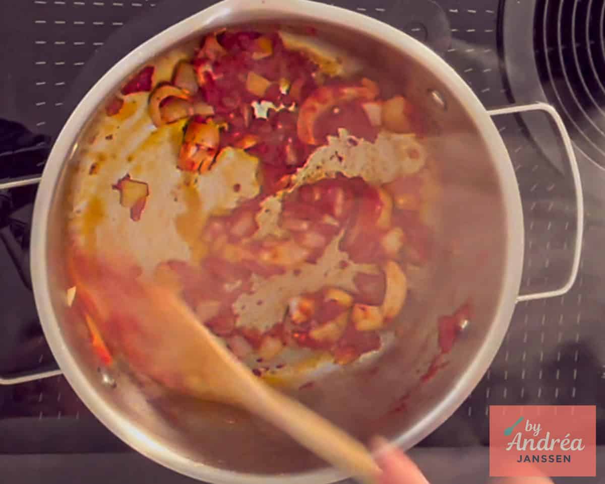 In de pan aanbakken tomatenpuree, knoflook en ui