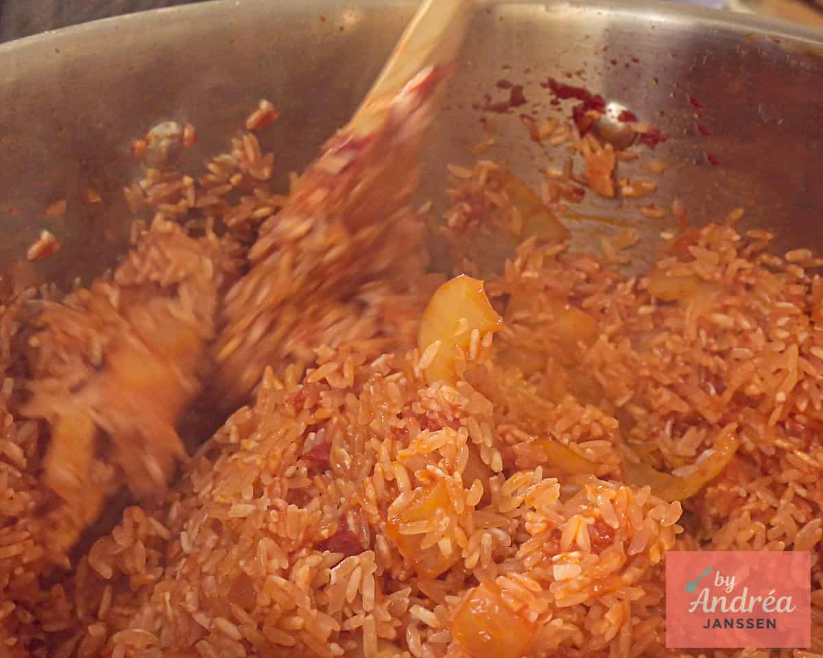 Aanbakken rijst in smaakmakers in de pan.