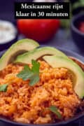 Een schaal met Mexicaanse rode rijst met avocado. Een tekst bovenin: Mexicaanse rijst, klaar in 30 minuten
