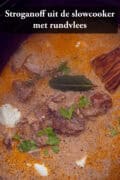 Een foto van bovenaf van een slowcooker gevuld met beef stroganoff. Een tekst bovenin: Stroganoff uit de slowcooker met rundvlees