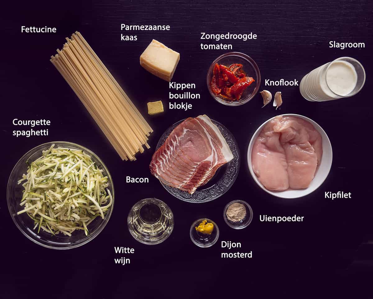Ingredienten Romige Pasta met Kip en Zongedroogde Tomaten op een zwarte ondergrond met tekst beschrijving