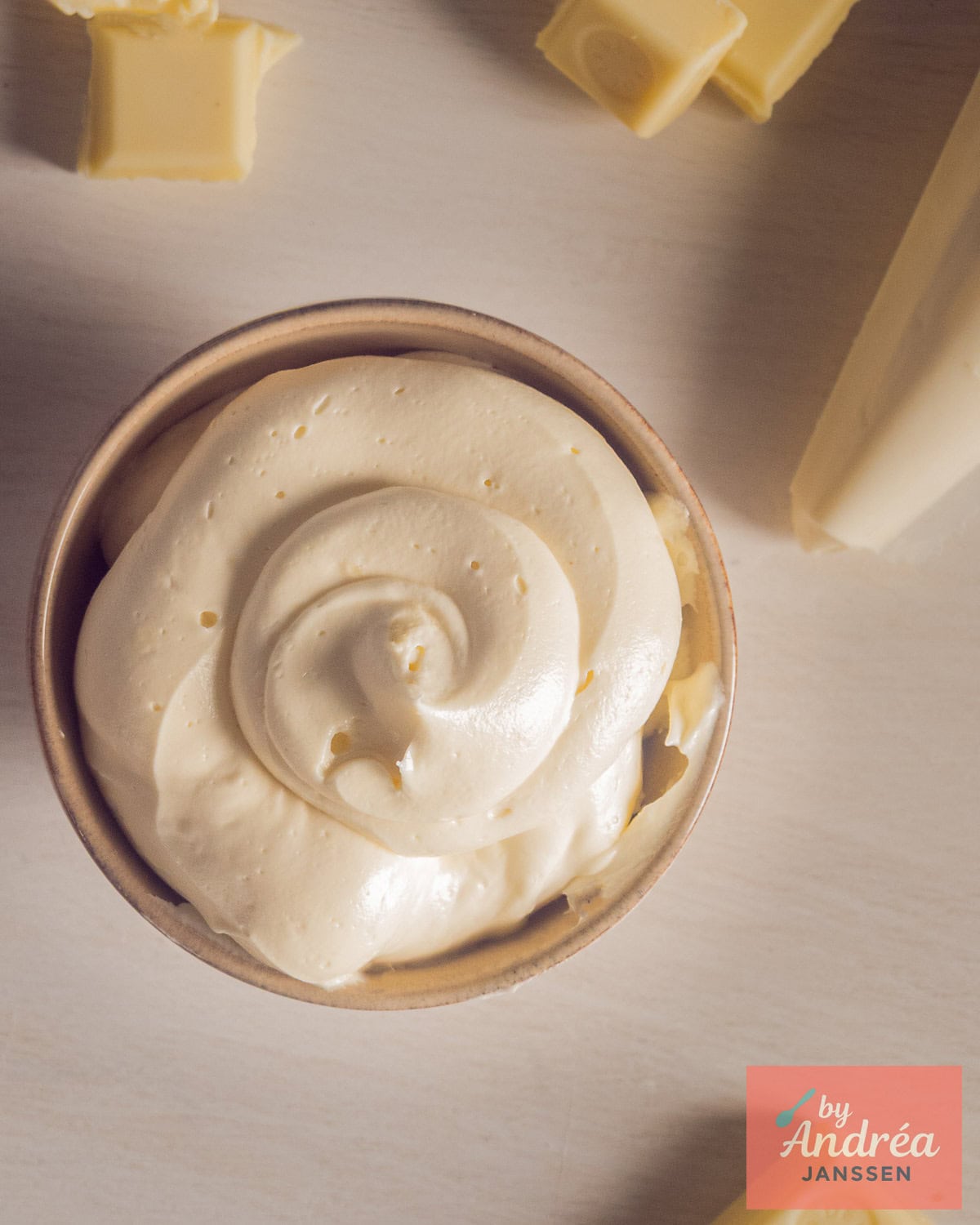 Een foto van bovenaf van een kom met Luchtige Botercrème met Witte Chocolade
