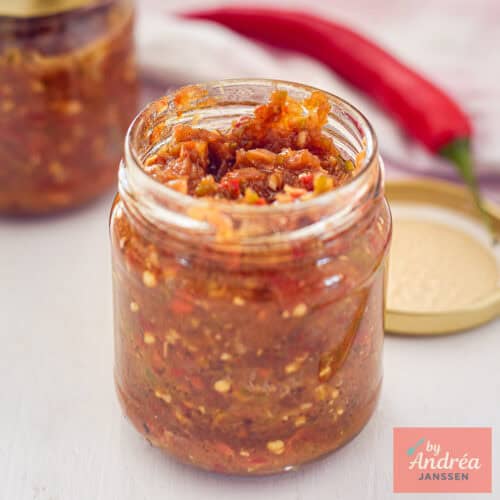 Een vierkante foto met een pot gevuld met sambal badjak.