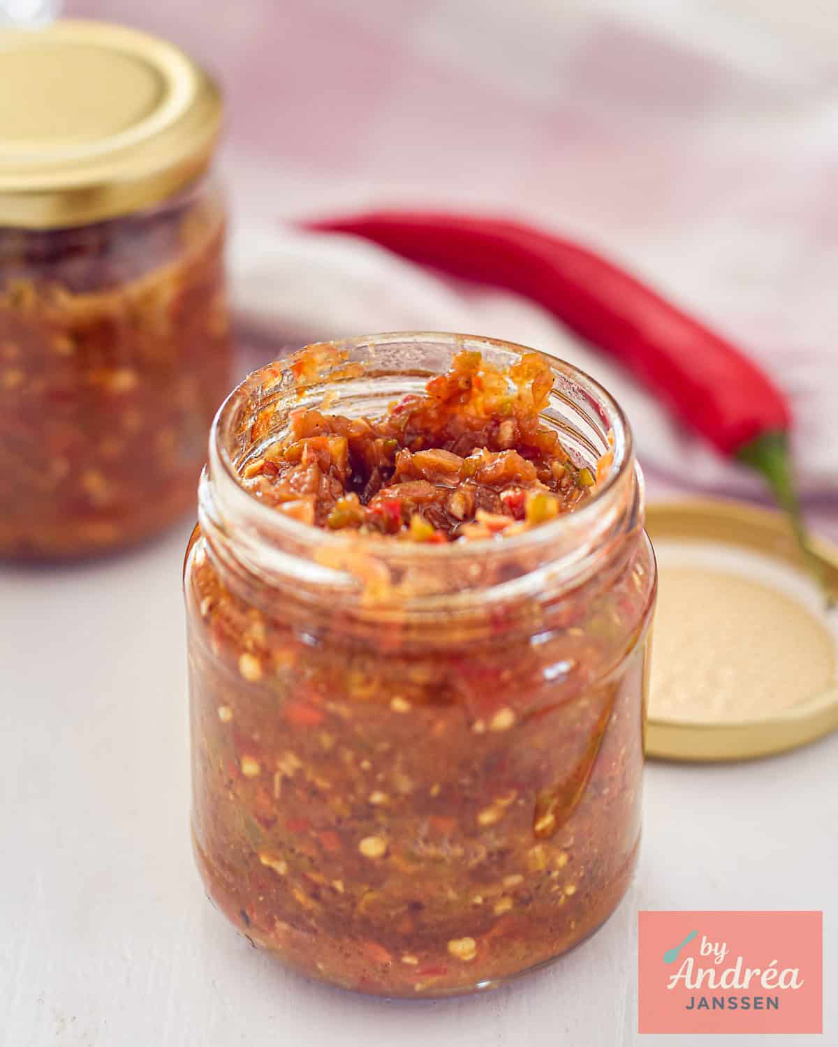 een glazen potje waar je Zelfgemaakte Sambal Badjak Maken met Verse Pepers