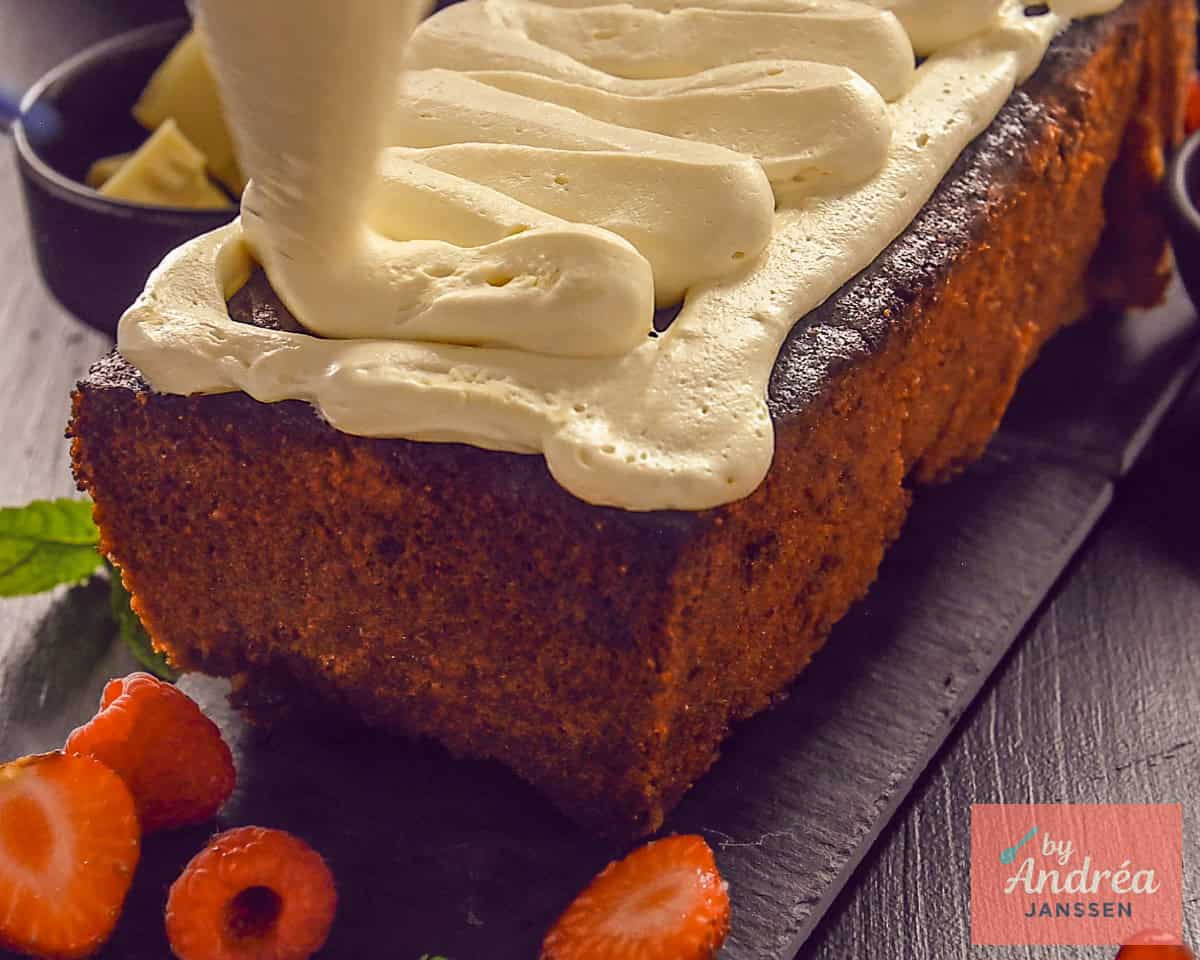 Spuiten van witte chocolade botercrème op een cake met een spuitzak