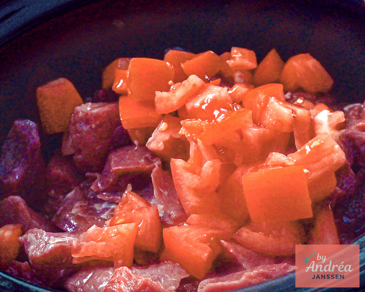 Blokjes rundvlees met ui, knoflook en tomaat in de slowcooker