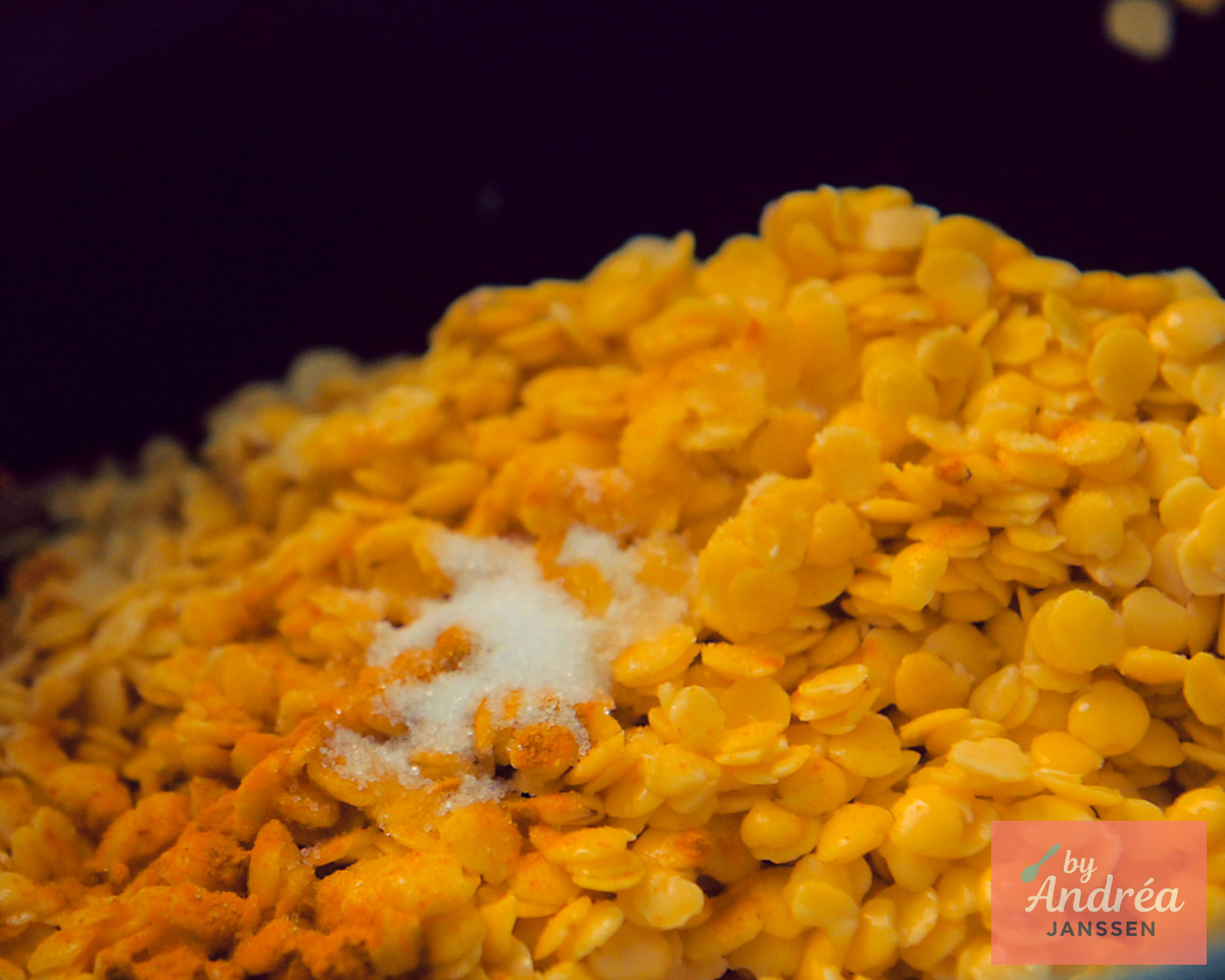 Ongekookte gele spliterwten met kurkuma en zout in de slowcooker voor dahl.