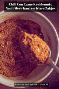 Zelfgemaakte chili con carne kruidenmix met komijn, paprikapoeder en cacao in een kommetje, met een lepel vol kruiden