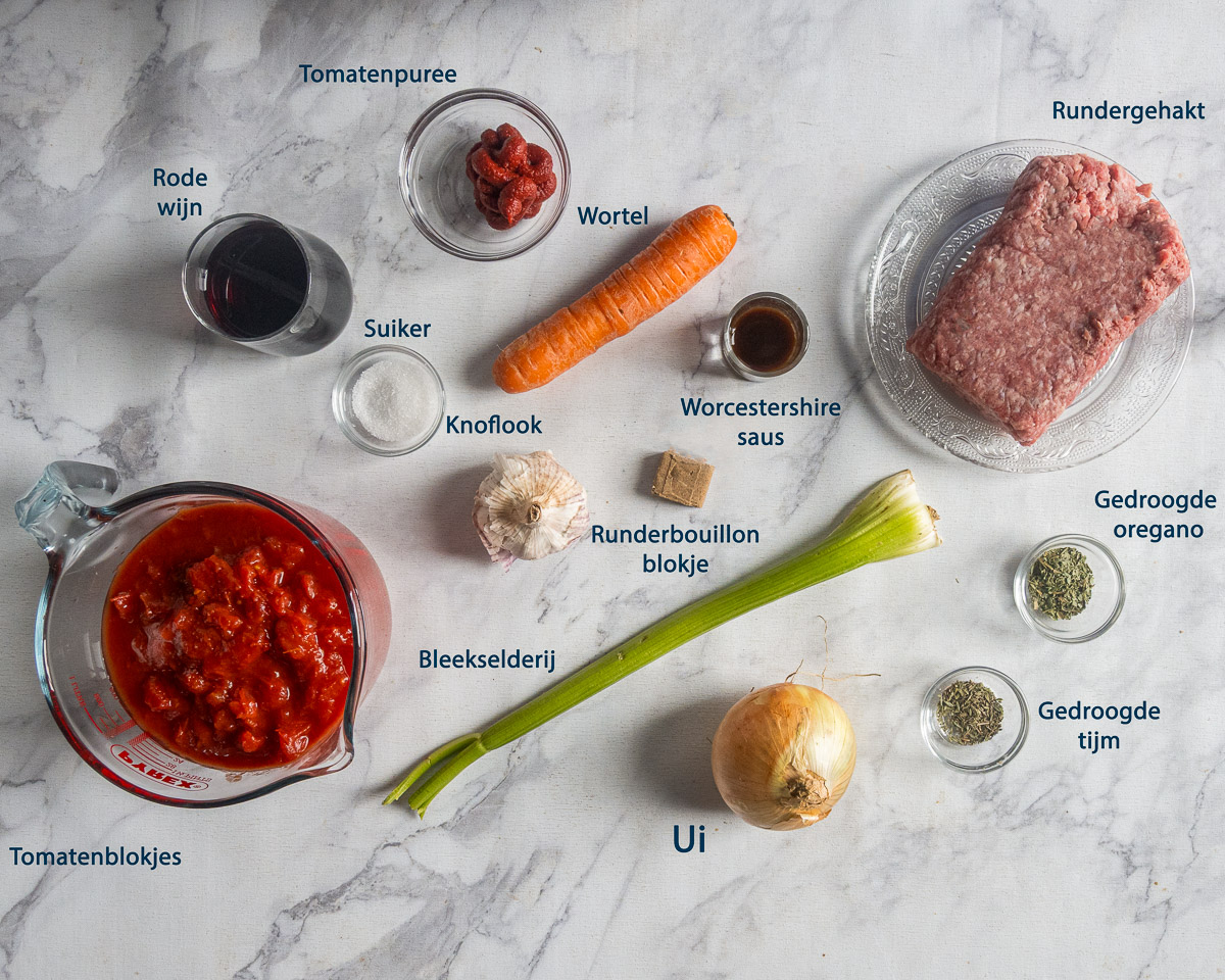 Ingrediënten voor lasagnesaus, waaronder rundergehakt, tomatenblokjes, wortel en rode wijn, met Nederlandse labels.