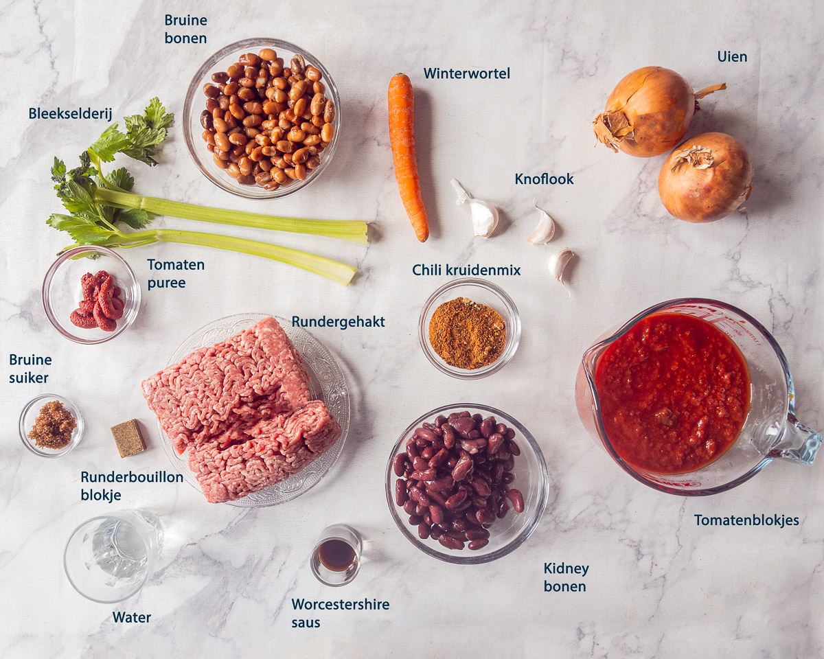 Gehakt, bruine bonen, kidneybonen, tomaten, ui, wortel, bleekselderij, knoflook en kruiden voor chili con carne uit de slowcooker.