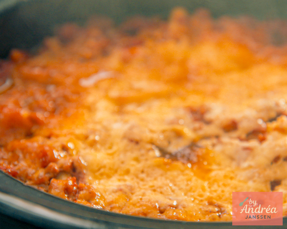 Close-up van lasagne in de slowcooker met gesmolten kaas en tomaten-gehaktsaus.