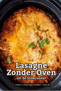 Bovenaanzicht van lasagne in een zwarte slowcooker. Bovenop ligt een goudbruine laag gesmolten kaas met donkere plekjes, langs de rand borrelt tomatensaus met gehakt. Een paar blaadjes verse peterselie liggen verspreid over de kaas. In beeld staat de tekst "Lasagne Zonder Oven, uit de slowcooker".